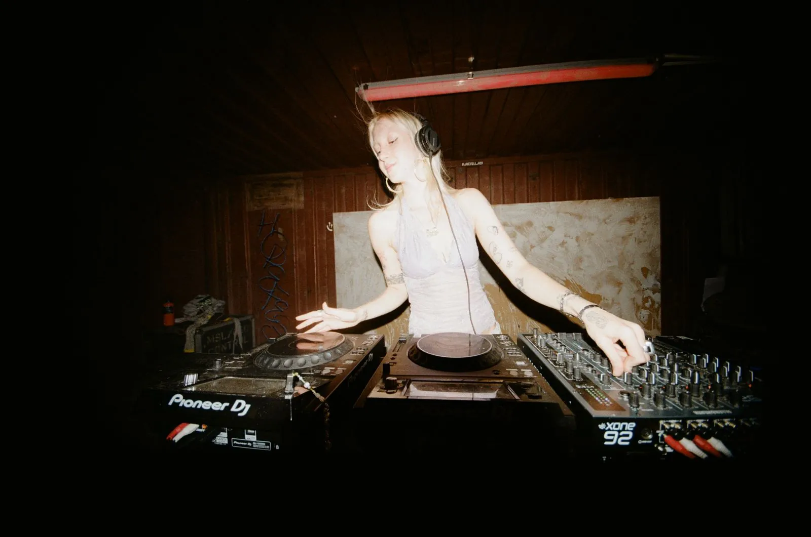 Nadja Volt at the decks in a wooden booth