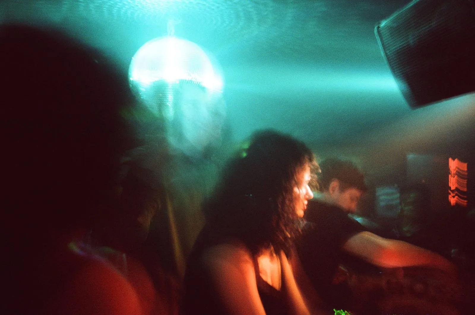 Dancers under a mirror ball in cyan light
