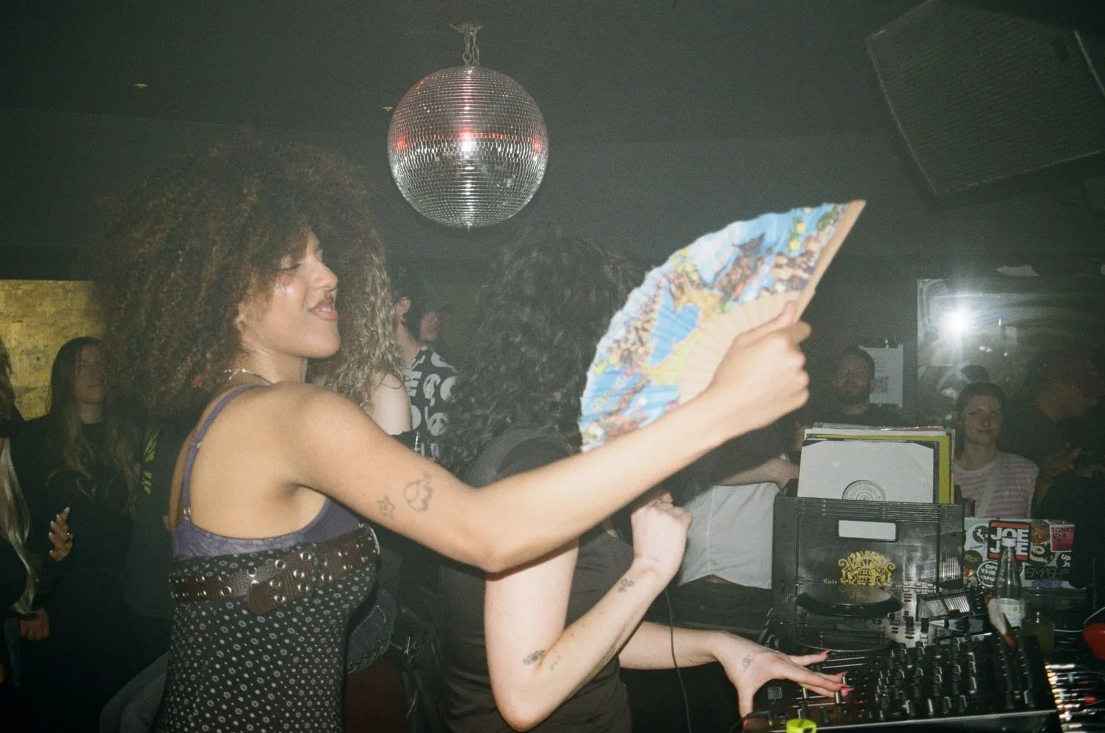 Dancer with a hand fan next to the booth